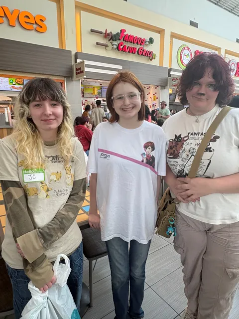 Three teens standing together in a bright, casual space